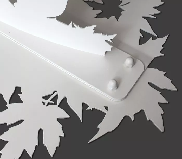 Détail du socle à feuilles d'érable découpé de la sculpture silhouette Kitsune
